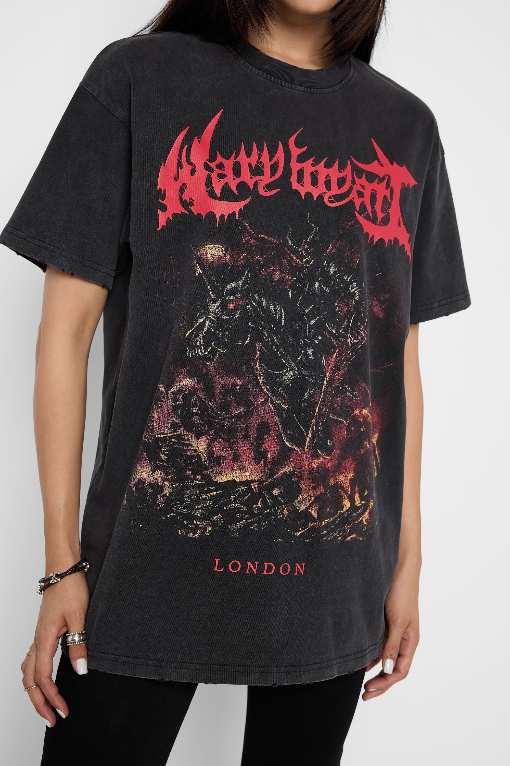 A person wearing an oversized black washed graphic T-shirt with a large red and dark illustration on the front, plus red text reading 'Mary Wyatt' at the chest and 'London' near the hem.
